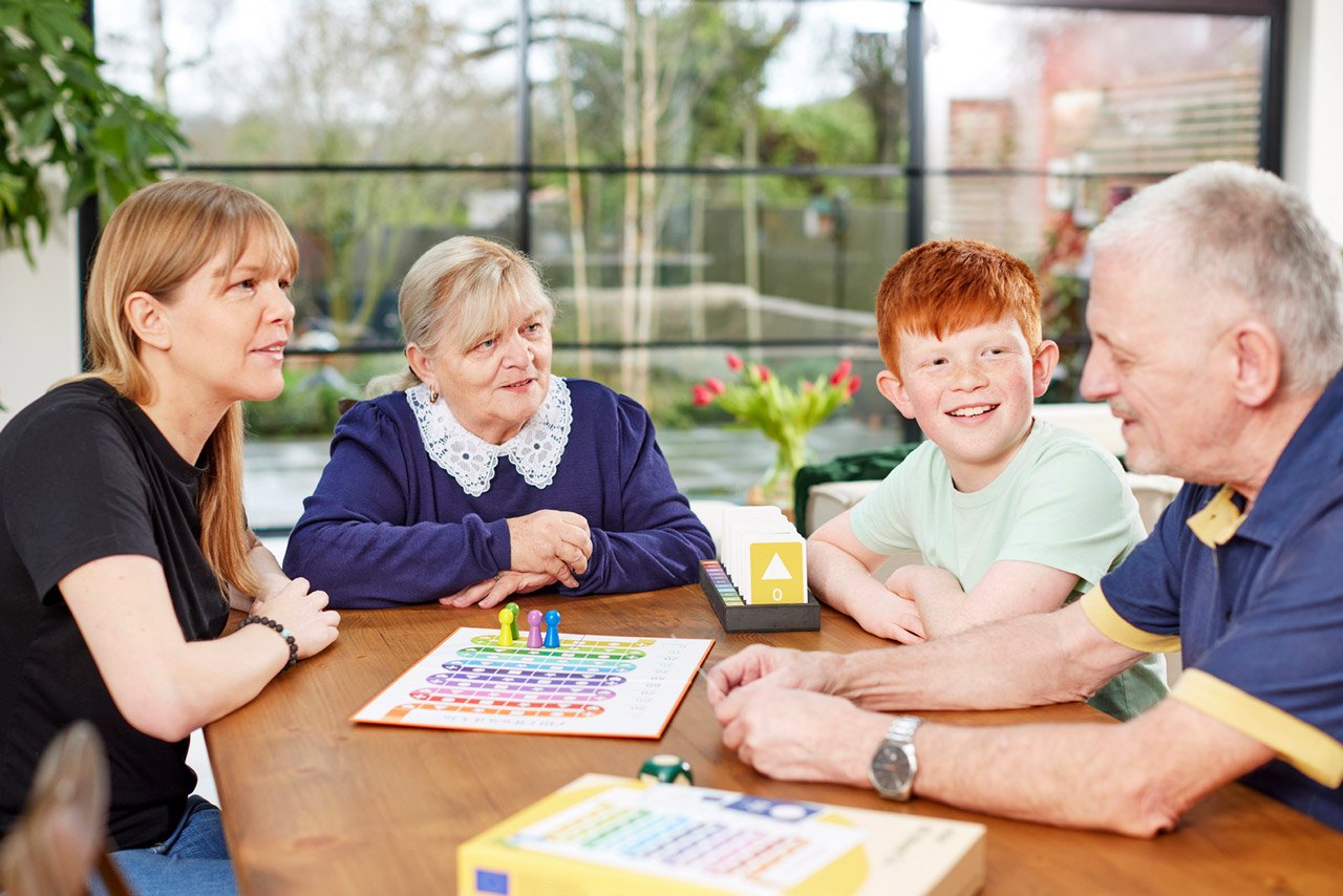 A family playing All About Us - an ideal Christmas gift for the elderly with dementia.