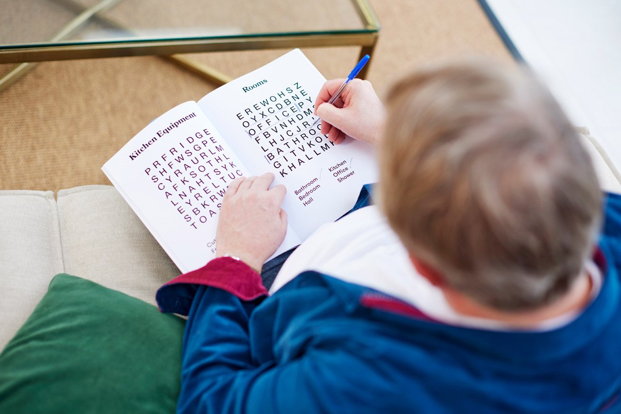 A man completing a dementia-friendly word search, a great Christmas gift for dementia.