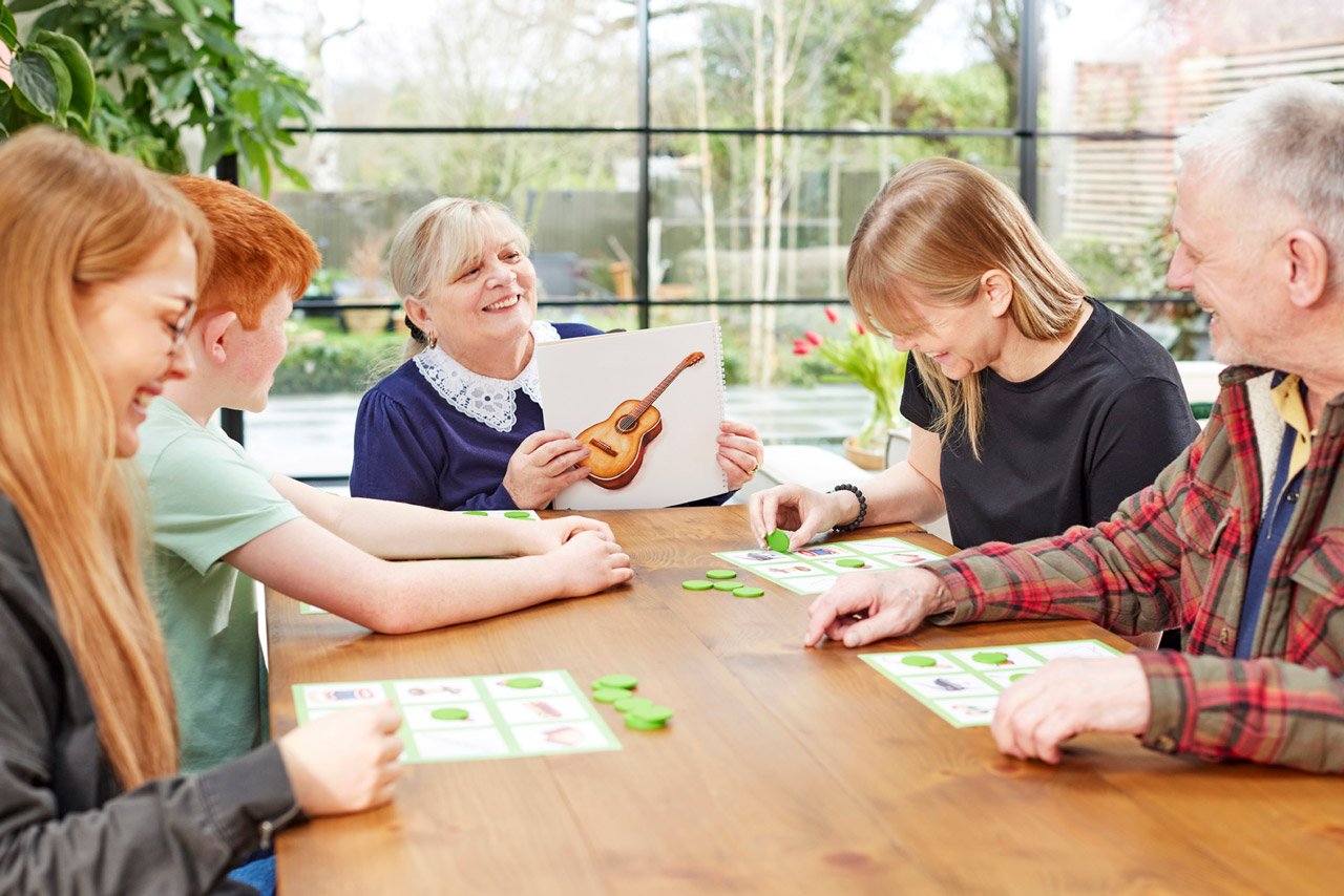 A family playing a dementia-friendly music bingo game - a top Christmas gift for people with dementia.